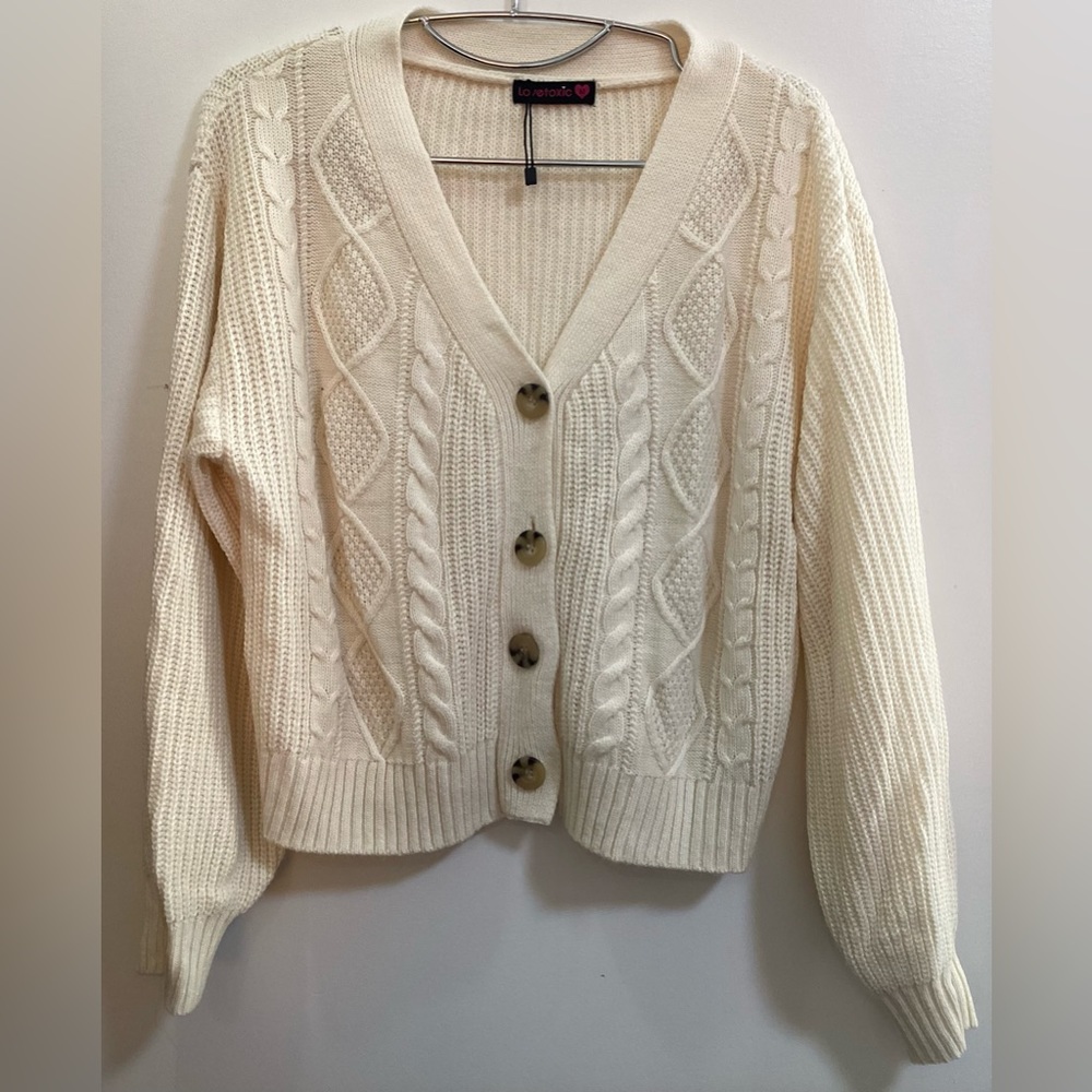 Knitted sweater with buttons and dropped shoulders.